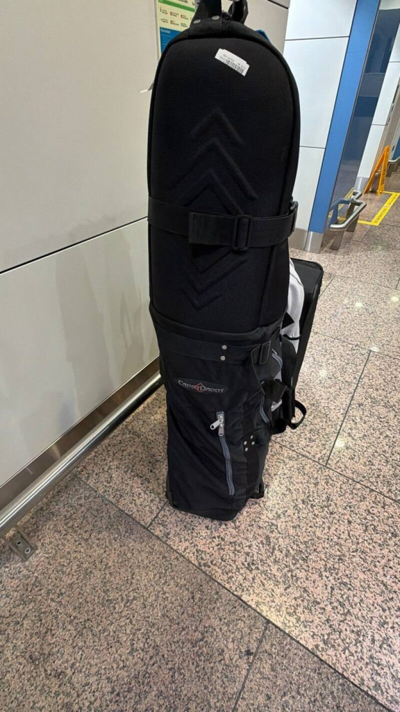 Caddy Daddy travel bag at the airport — about to cross three airlines and two continents