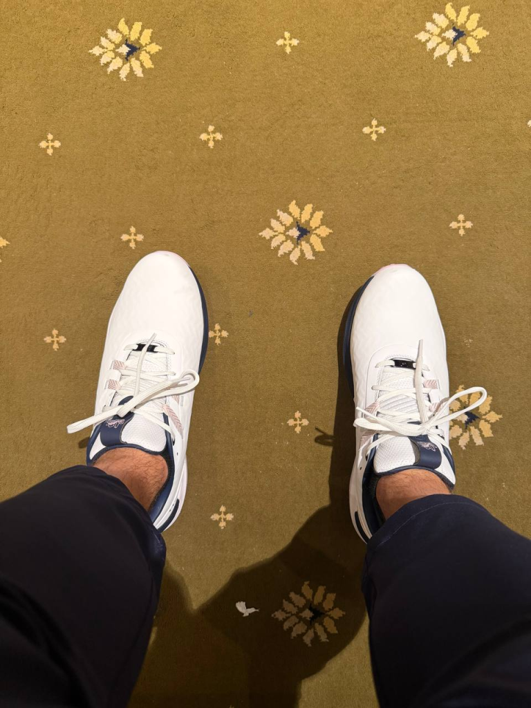 White golf shoes on Locker Room carpet